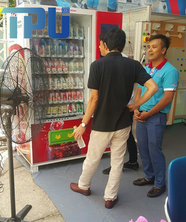 Nhân viên TPA hướng dẫn khách sử dụng máy bán hàng tự động